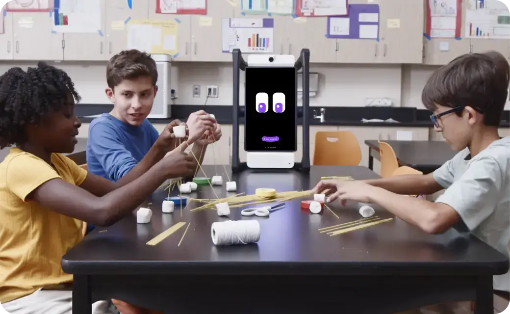 Alt:M2 device on the teacher’s desk, co-teaching with the instructor in a classroom.Students working in a small group with M2 guiding the activity.