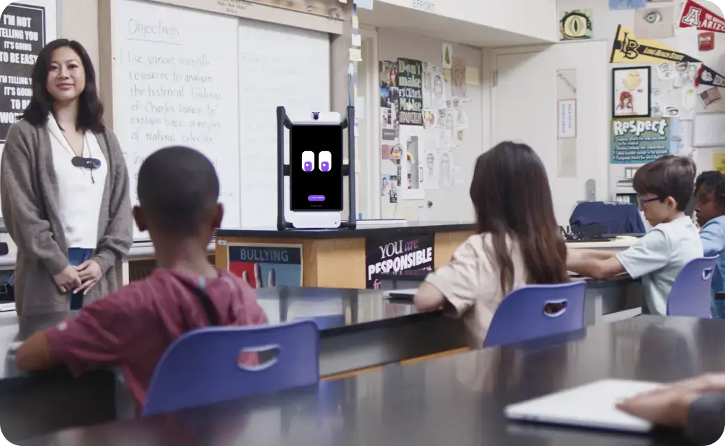 Alt:M2 device on the teacher’s desk, co-teaching with the instructor in a classroom.Students working in a small group with M2 guiding the activity.