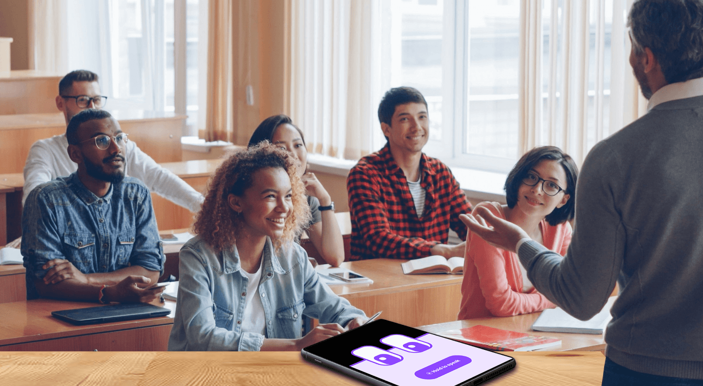Teacher leading an engaged classroom discussion while students participate attentively, with a tablet showing the M2talk participation interface in the foreground.