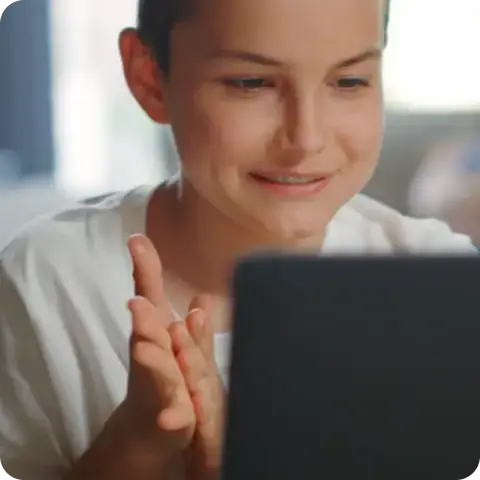 A smiling student looking at a laptop screen during a lesson.