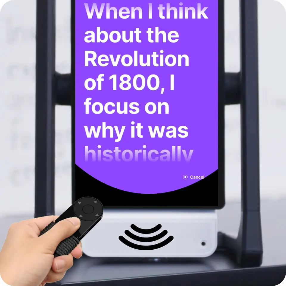 A close-up of M2 displaying educational text with a hand holding a remote control